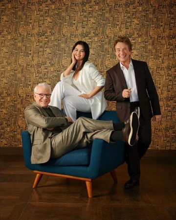 Three adult actors – Selena Gomez, Steve Martin, and Martin Short – pose in suits in an indoor portrait against a patterned backdrop.