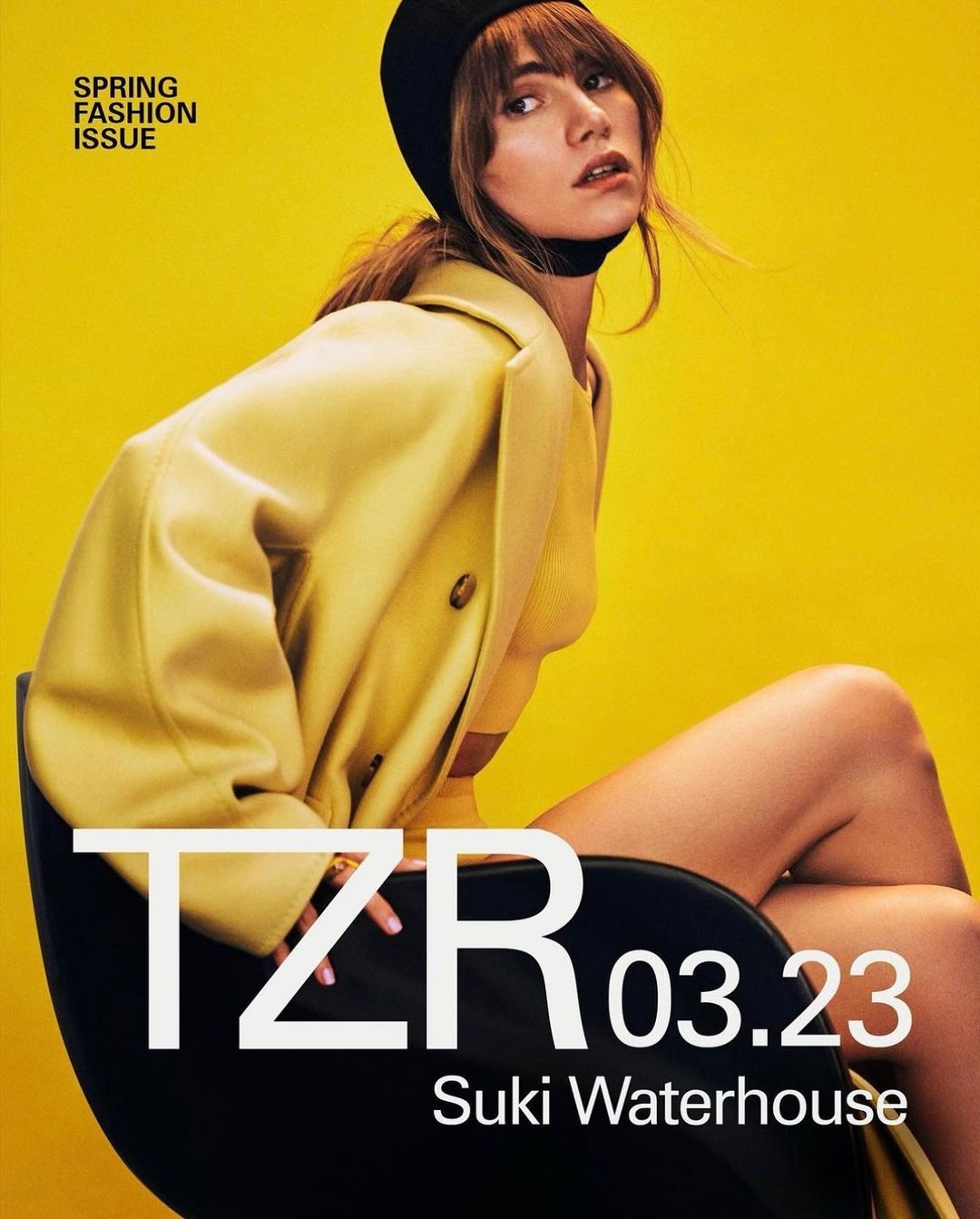 Magazine cover featuring Suki Waterhouse in a yellow coat and black beanie against a yellow background with bold white text.