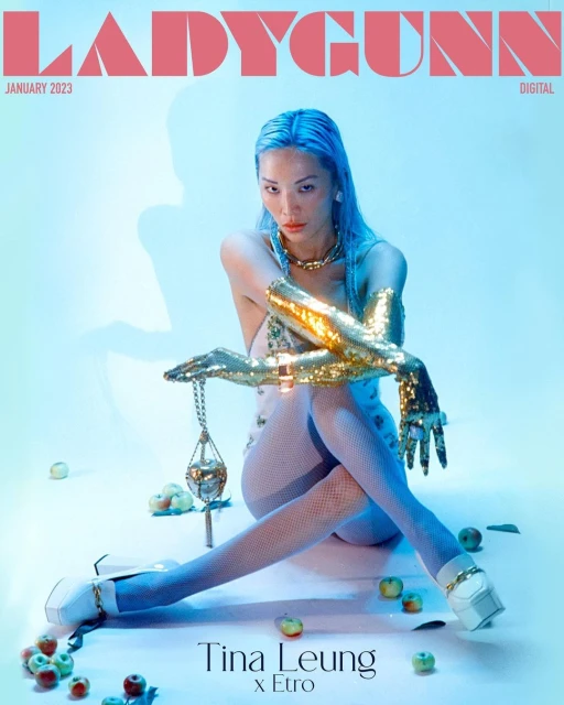 Ladygunn magazine cover featuring Tina Leung wearing shimmering gold sleeves and sitting amid green apples in a photo studio.