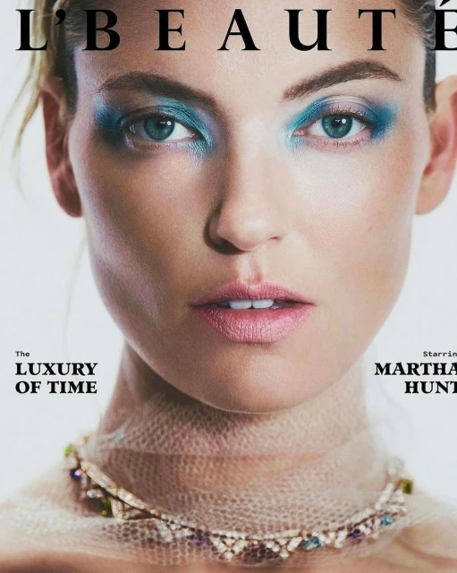 Close-up magazine cover featuring a woman with blue eyeshadow and a jeweled necklace, highlighting beauty and fashion elements.