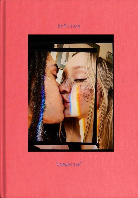 Close-up of two people with rainbow light kissing, framed by a pink book cover with the words 'DSECTION' and 'CONNECTED'.