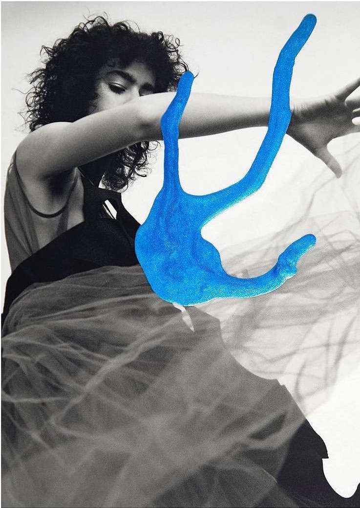 Artistic black and white portrait of a woman with curly hair and an open-armed pose juxtaposed with a digitally added bright blue sculpture.