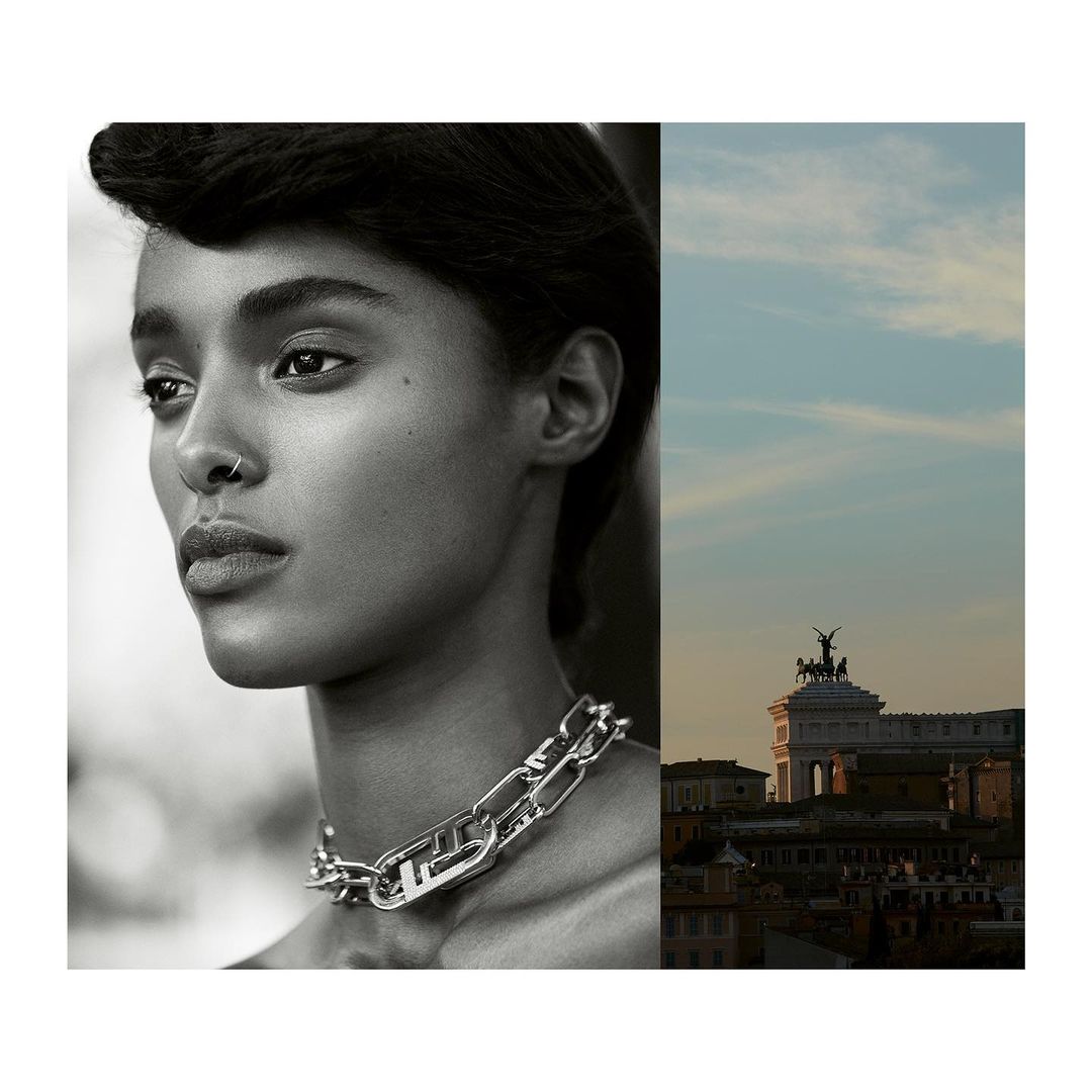 Close-up black and white portrait of a young woman with a chain link necklace, juxtaposed with a cityscape and cloudscape.