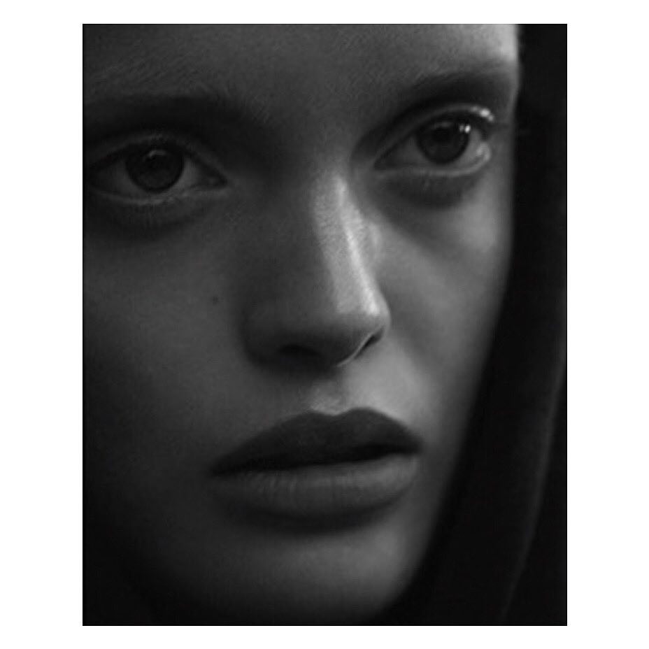 Monochrome portrait of a young adult woman with dark hair, gazing pensively into the distance, emphasizing a close-up of her face.