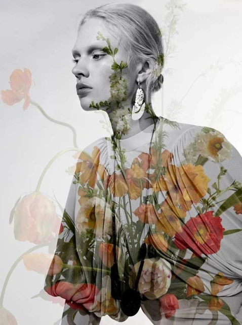Artistic fashion portrait of a woman with floral dress and botanical overlay on a white backdrop, earring detail.