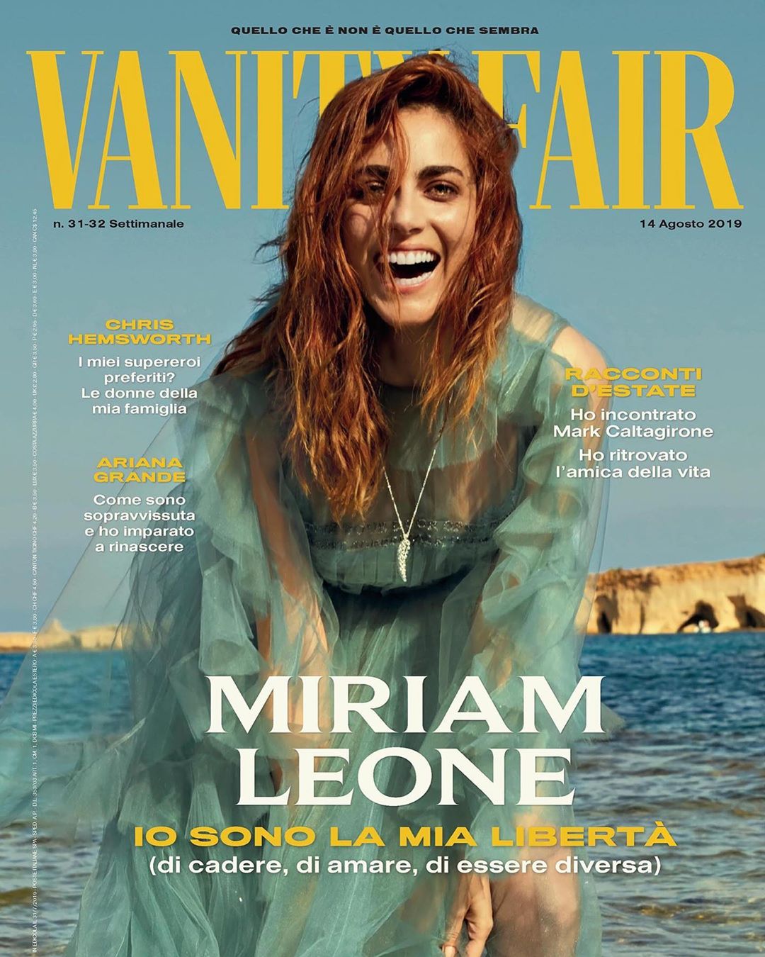 Magazine cover featuring Miriam Leone in a teal dress, smiling against a sunny sky and ocean backdrop with Vanity Fair masthead.