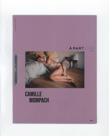 Art magazine cover featuring a reclining person on a bed with a lamp and books in the background, set against a lavender-colored background.