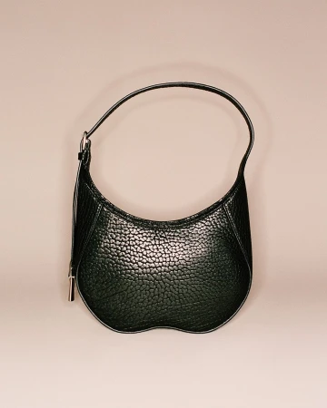 Stylish black pebbled leather handbag with a curved shape and a single handle, displayed against a soft, neutral background. Fashion accessory.