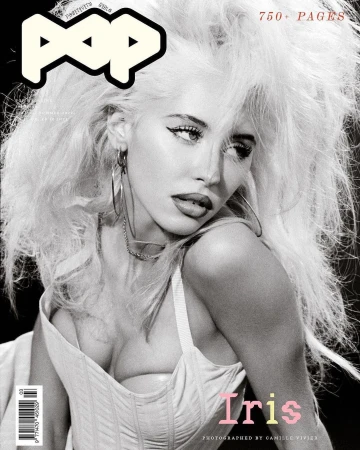Monochrome magazine cover featuring a woman with voluminous blonde hair wearing hoop earrings and a light-coloured corset top.