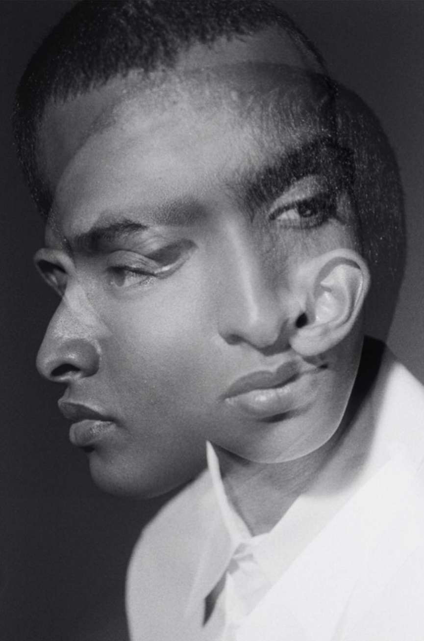 Monochromatic portrait of a Black man with a thoughtful expression created through a multiple exposure photography technique in a studio.