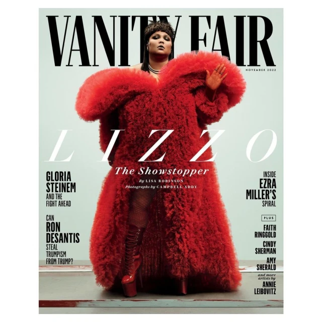 Lizzo on Vanity Fair magazine cover, November 2023. She is wearing a large red fur coat, knee-high red boots, and a beaded head covering.