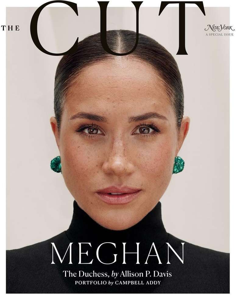 Magazine cover featuring a close-up portrait of Meghan Markle, who is wearing green earrings and a black turtleneck against a pale background.