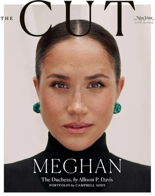 Magazine cover featuring a close-up portrait of Meghan Markle, who is wearing green earrings and a black turtleneck against a pale background.
