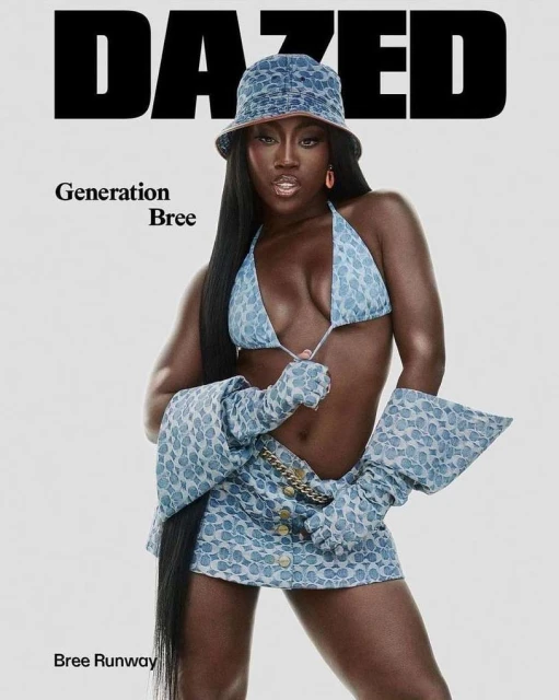 An adult woman in a denim-patterned two-piece outfit and bucket hat poses for a magazine cover against a white background.