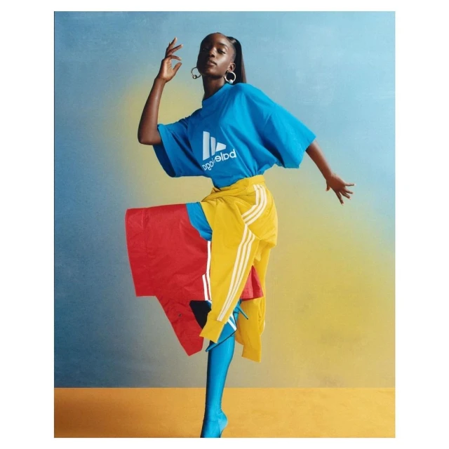 A striking fashion shot features an adult woman in an athletic-branded blue tee, yellow bottoms, and blue-painted legs against a gradient backdrop.