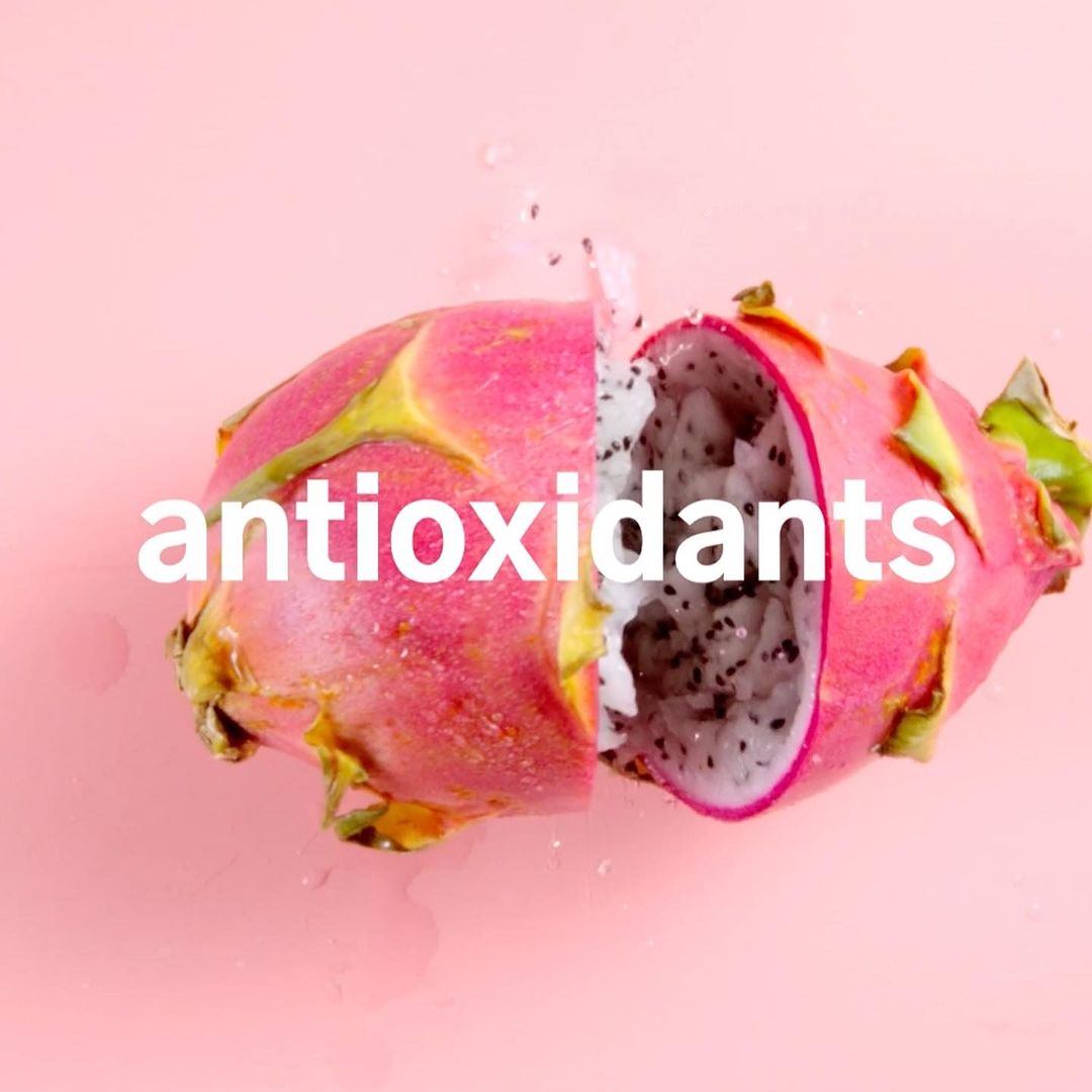 Sliced dragon fruit on a pink background, showcasing the white flesh and black seeds. Close-up, still life, food photography.