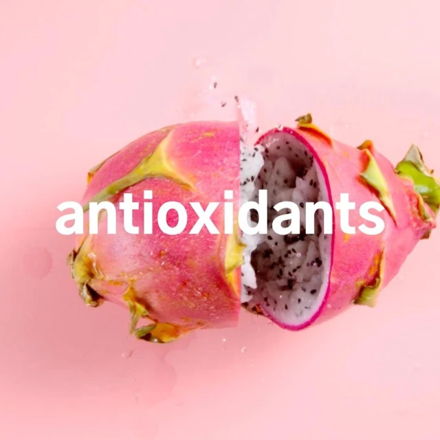 Sliced dragon fruit on a pink background, showcasing the white flesh and black seeds. Close-up, still life, food photography.