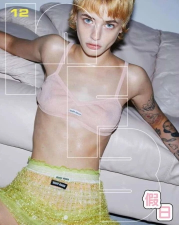 Close-up portrait of a blonde woman wearing a pink bralette and textured lime green skirt against a white leather sofa.