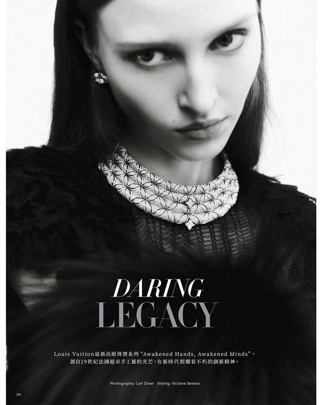 Monochrome portrait of a woman with long dark hair wearing an ornate diamond necklace and earring, set against a blurred background.