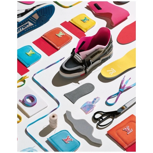 Flat lay photograph of deconstructed Louis Vuitton sneaker with interchangeable parts and accessories on a white background.