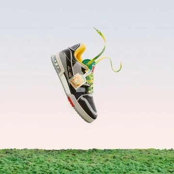 A single black and grey athletic shoe hovers above a textured green field against a gradient light blue to pink sky. Yellow details.