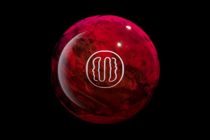 Close-up of a red bowling ball with a white logo against a black background, showcasing a striking contrast and a smooth, polished surface.