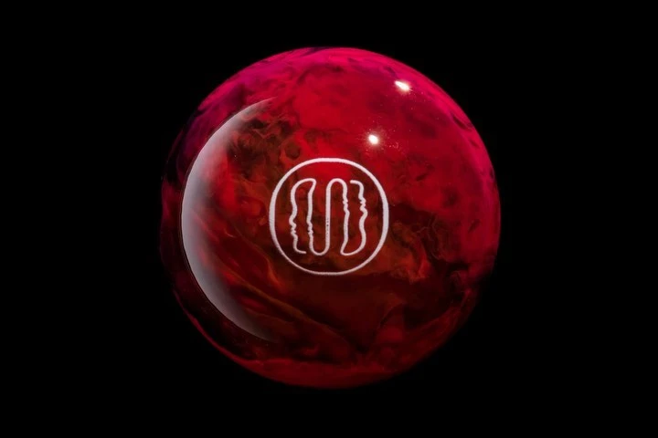 Close-up of a red bowling ball with a white logo against a black background, showcasing a striking contrast and a smooth, polished surface.