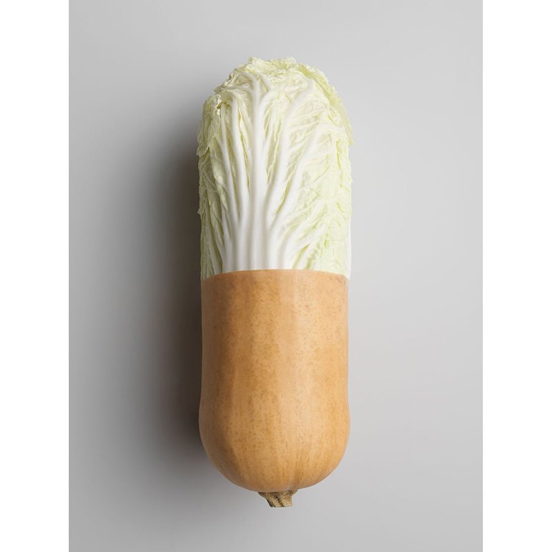 Creative food photography: a vegetable art piece of a Chinese cabbage atop a butternut squash on a simple gray background.