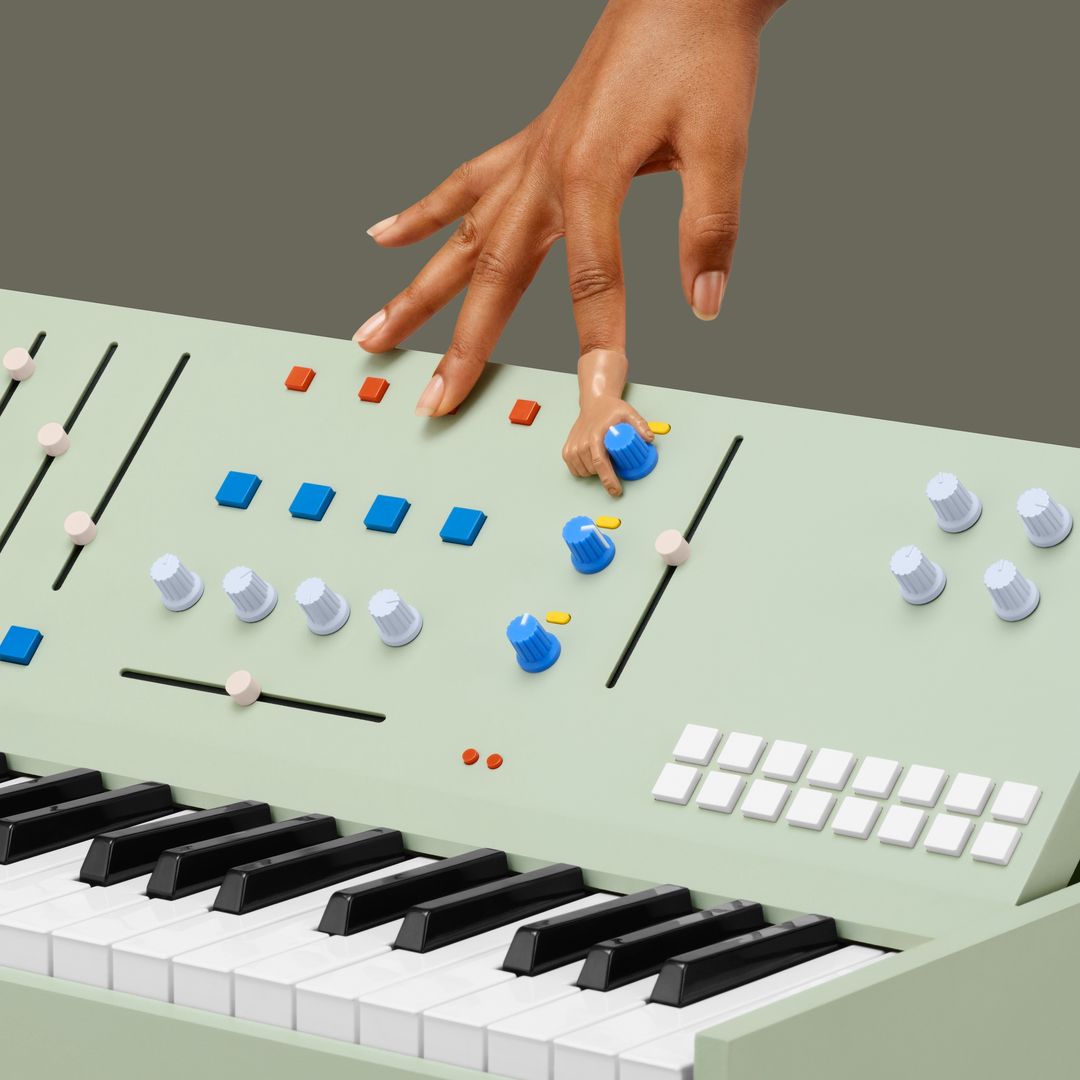 Close-up of an adult hand adjusting the knobs on a green synthesizer with black and white keys on a solid background.