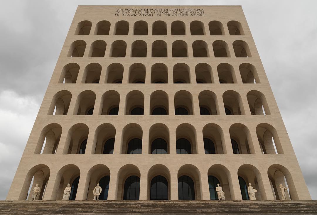 Fascist-era architecture in Rome, Italy, featuring the Palazzo della Civiltà Italiana with its iconic arches and classical statues.