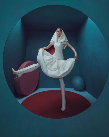 Woman in a couture white dress and matching hood poses inside a circular blue doorway with red and blue geometric shapes.