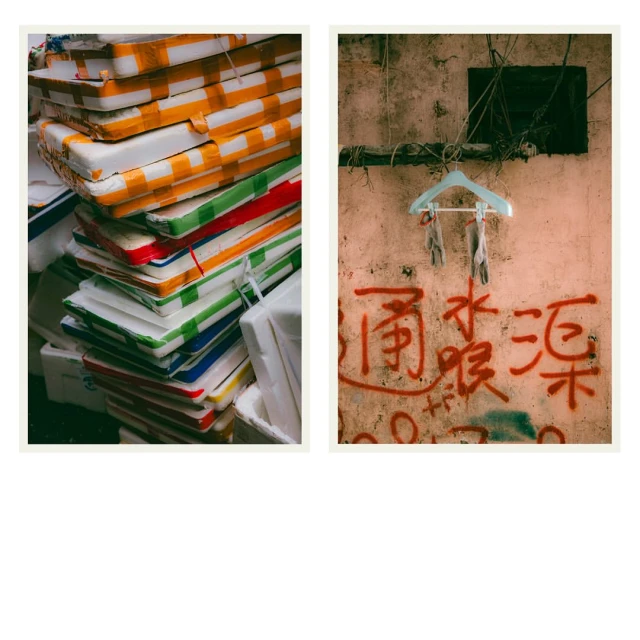 Still life with colorful stacked boxes next to wall with graffiti art featuring script and hanging clothes hanger. 