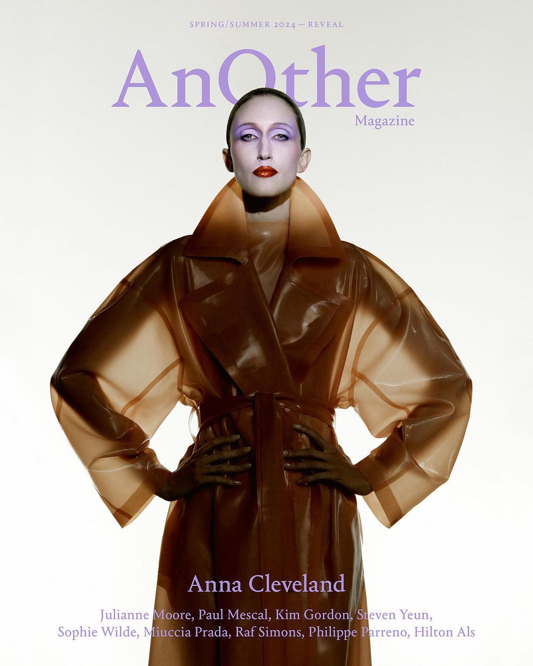 Fashion magazine cover featuring Anna Cleveland wearing transparent brown trench coat, dramatic eye makeup and red lipstick, against white backdrop.