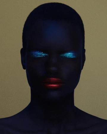 Close-up portrait of a Black woman with dark blue painted skin, glowing turquoise glitter eye makeup, and bold red lips against a gold backdrop.