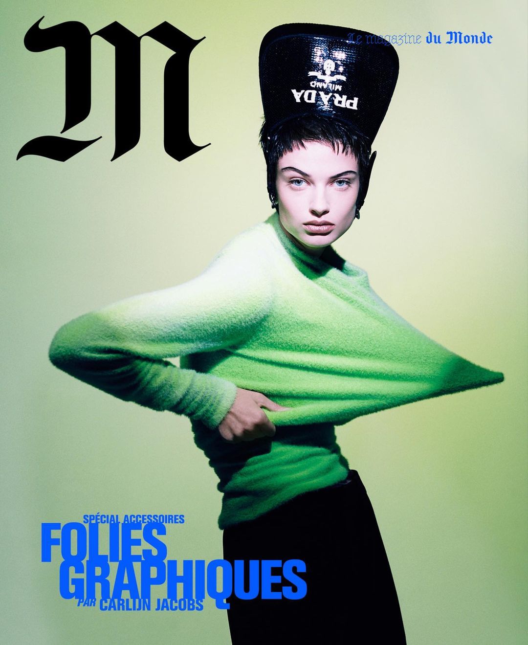 Magazine cover featuring a stylish model wearing a green sweater and a black Prada hat, with blue text on a yellow background.
