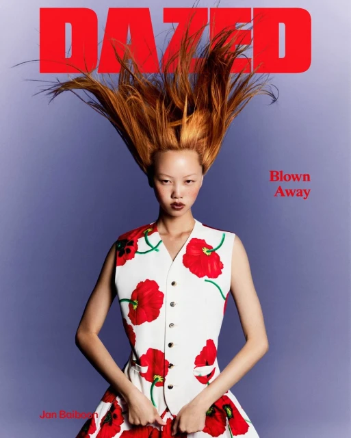Magazine cover featuring an Asian female model with copper hair, wearing a poppy-print outfit, against a periwinkle gradient background.