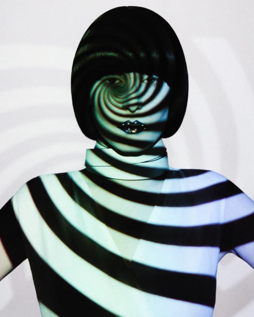 Fashion portrait of an adult woman with a short bob hairstyle and striped pattern projection on her face and body against a white backdrop.
