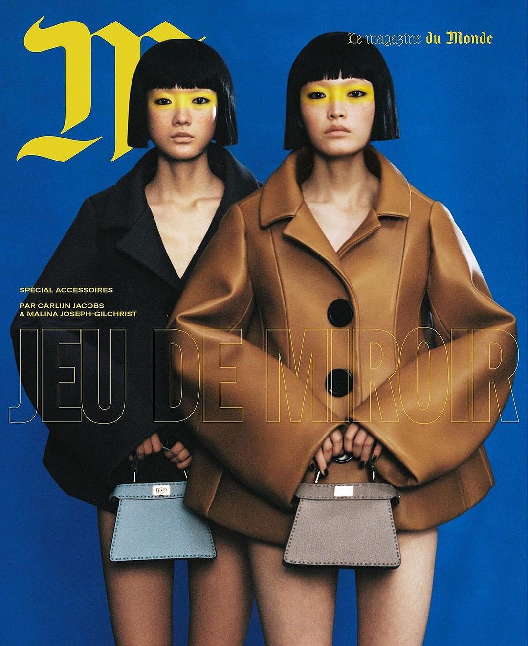 Magazine cover featuring two women with yellow eyeshadow, short black bob haircuts, wearing structured coats and holding mini handbags.
