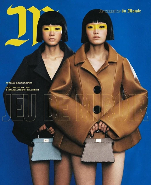 Magazine cover featuring two women with yellow eyeshadow, short black bob haircuts, wearing structured coats and holding mini handbags.