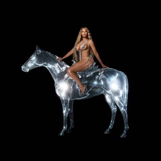 Beyonce poses atop a sparkling silver horse sculpture in a dark studio, exuding celebrity and entertainment glamour with dramatic lighting.