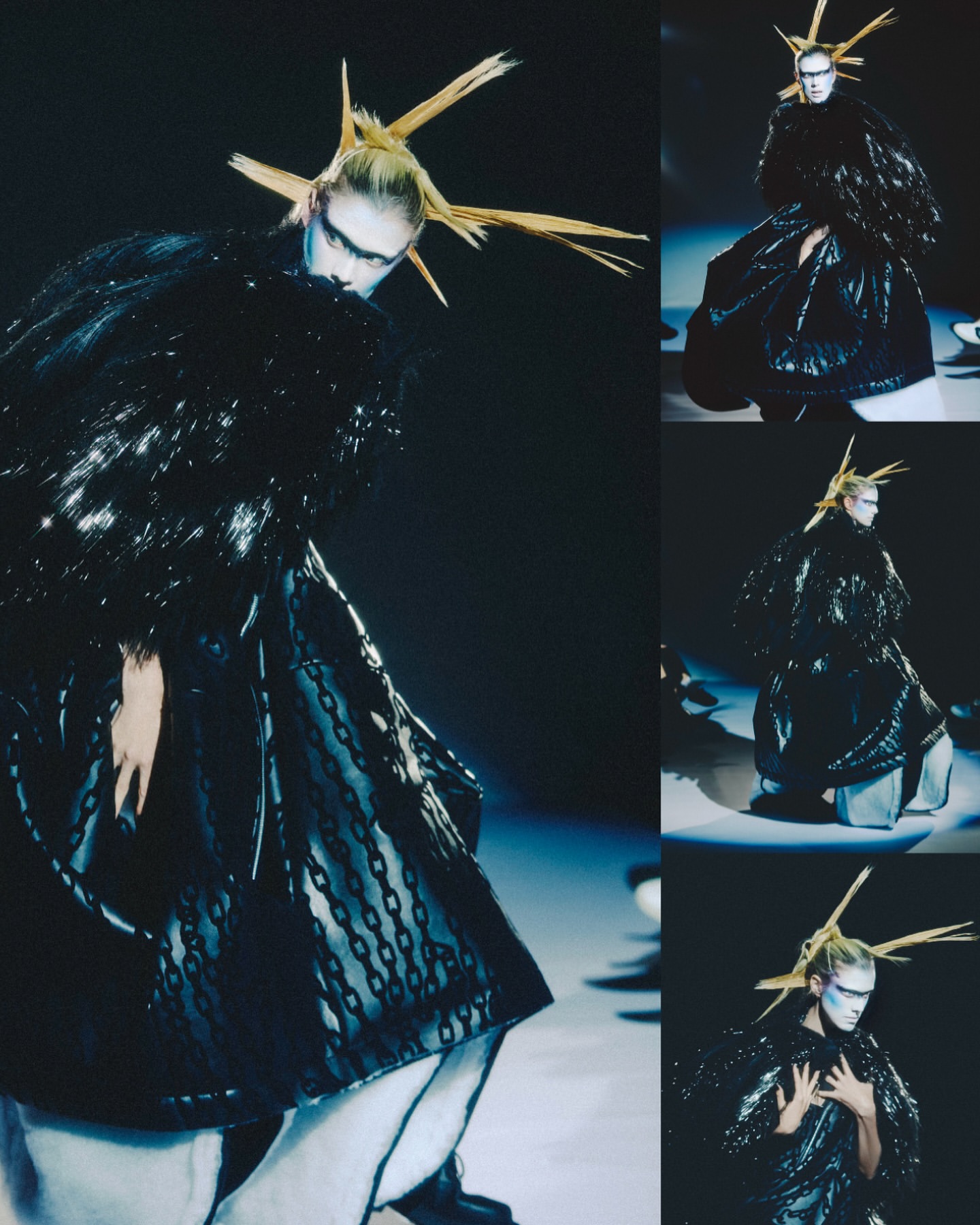 Runway fashion show featuring a model in an elaborate, dark couture gown with avant-garde styling and bold makeup against a dark background.