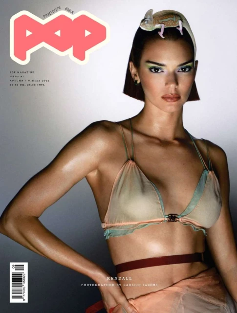 Magazine cover featuring Kendall Jenner wearing a bra top and a decorative chameleon perched on her head, set against a gradient background.