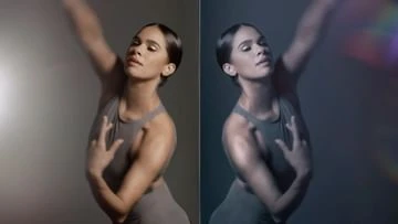 Portrait of a woman in a gray bodysuit strikes a dance pose, showcasing grace and strength against soft gray and dark backgrounds.