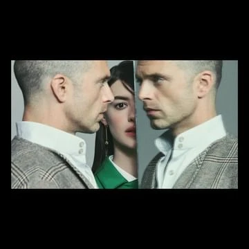 Three people pose in front of a grey background, with two men facing away from each other and a woman's face in the middle.