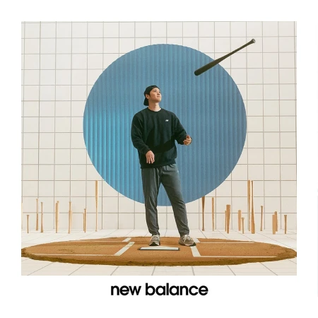An Asian man in casual clothing stands on a baseball diamond with a floating bat, set against a graphic tiled backdrop and circle.