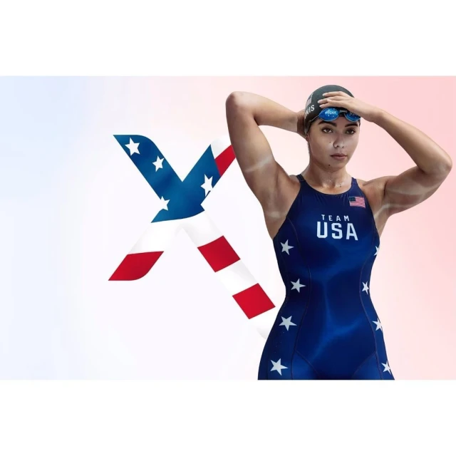 Female athlete in blue USA swimsuit and swim cap adjusting goggles, with an American flag graphic overlay on a white background.
