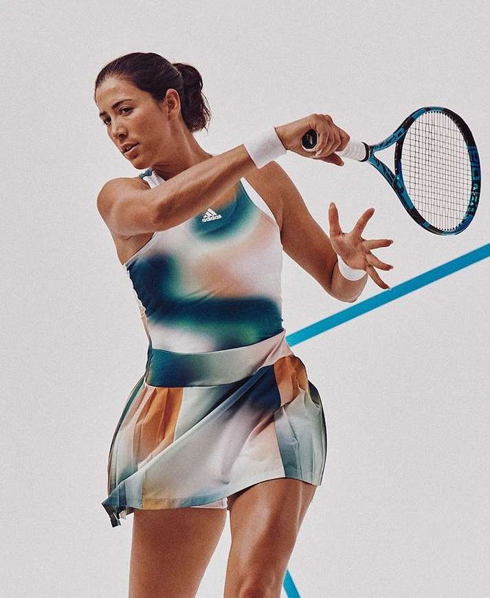 Female tennis player in action pose, wearing a colorful tennis dress, holding a racket, set against a light background with a blue line.