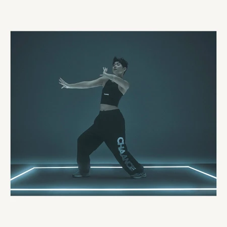 Male dancer in dark athleisure wear poses expressively against a dark backdrop with glowing lines. Modern dance and fashion concept.