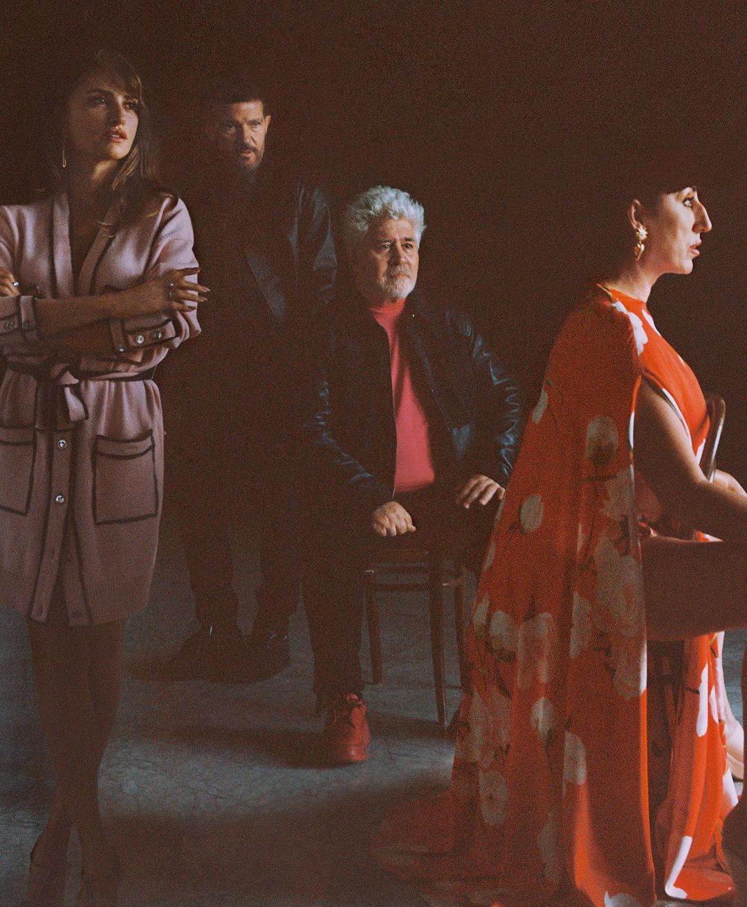 Group portrait of four adults: two women, two men. The shot is lit with warm tones in a photo studio setting. 