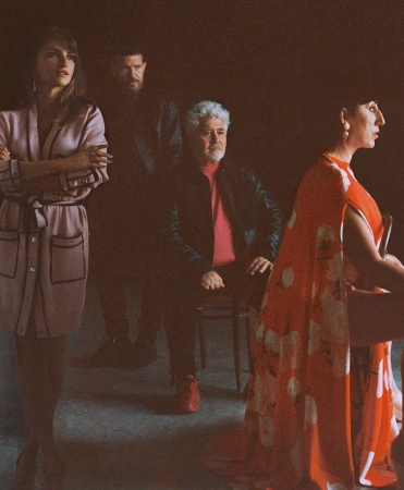 Group portrait of four adults: two women, two men. The shot is lit with warm tones in a photo studio setting. 